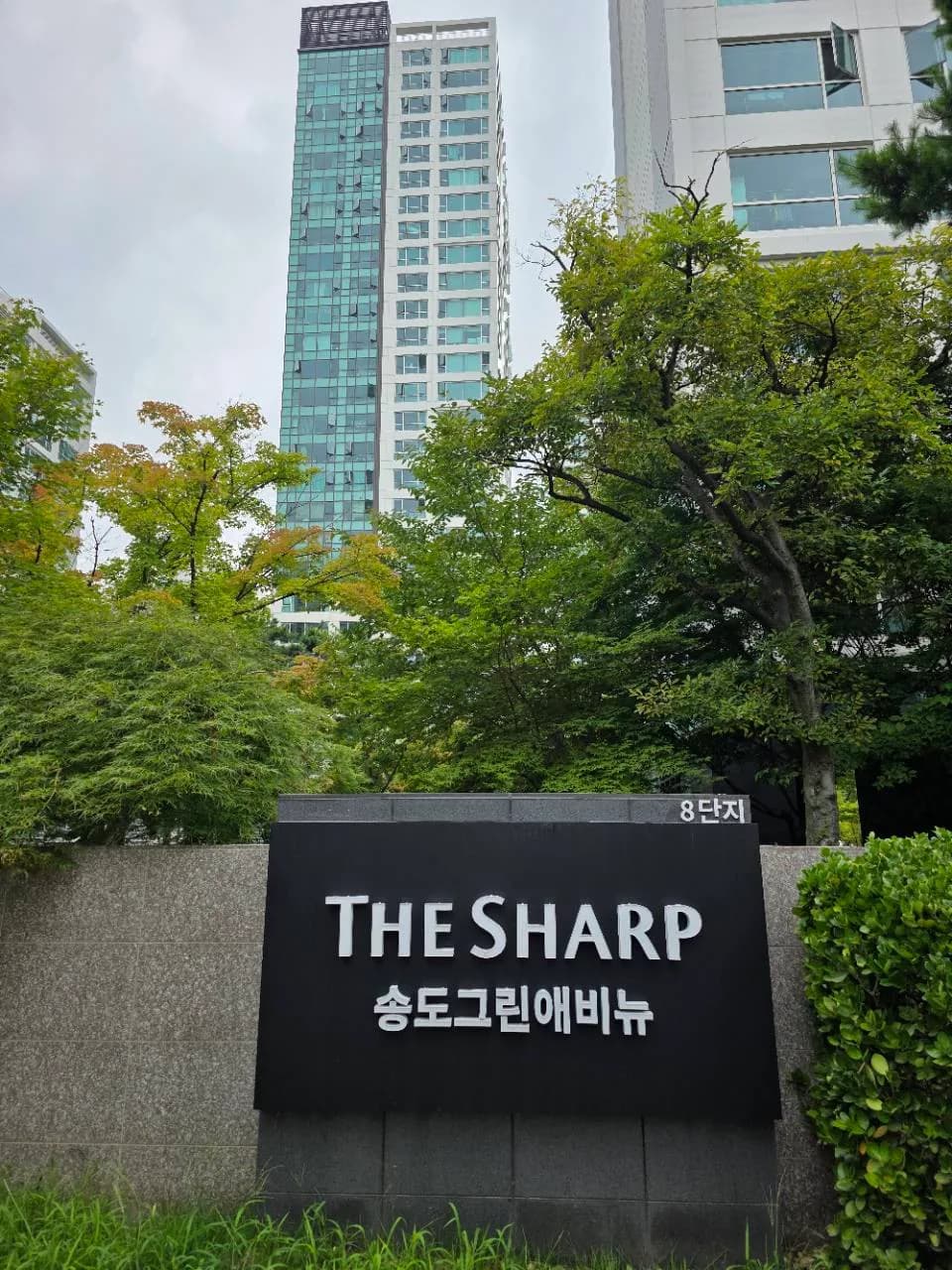 송도더샵그린애비뉴8단지 표지석과 아파트 외관
